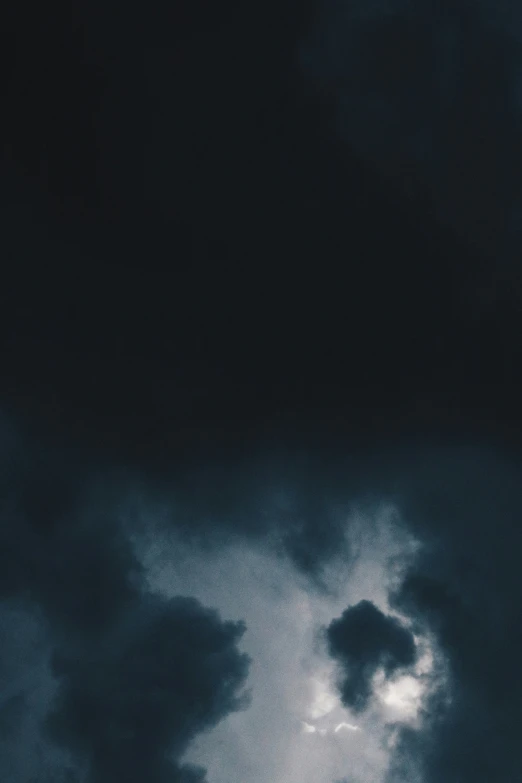 the dark clouds are covering a building and tower