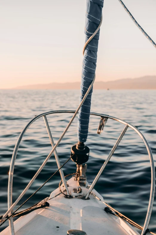 a sailboat sails through the water with a rope that hangs down