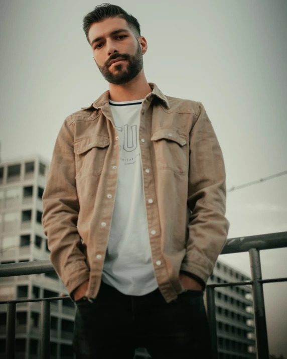 a man with dark hair and beard wearing a jacket