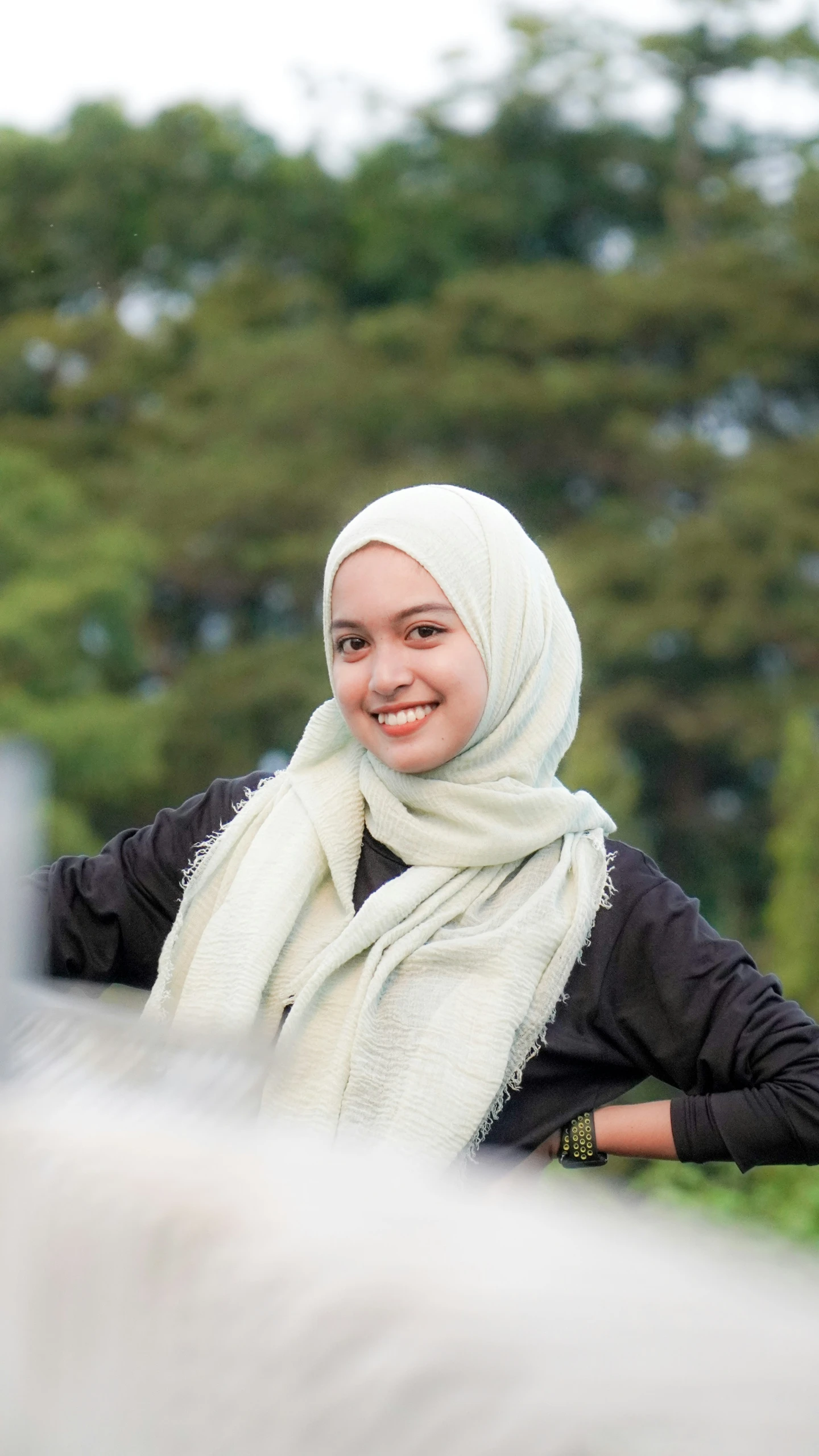 a woman in a hijab is standing outside