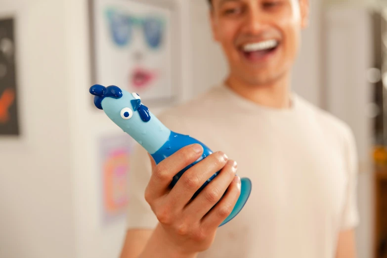 man holding blue toy with white face in living room