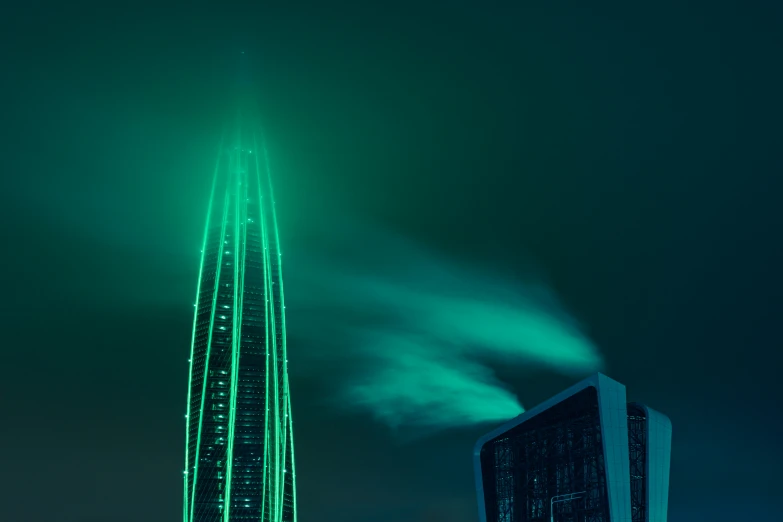 a green skyscr that is lit up at night