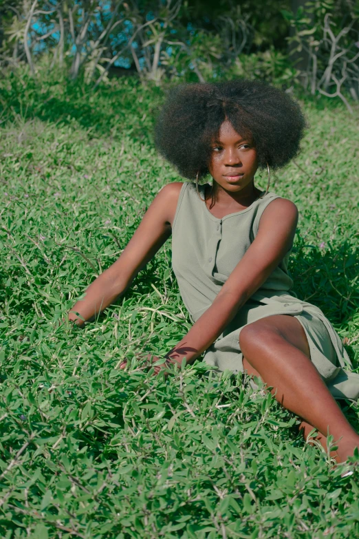 a woman sitting on top of a lush green field