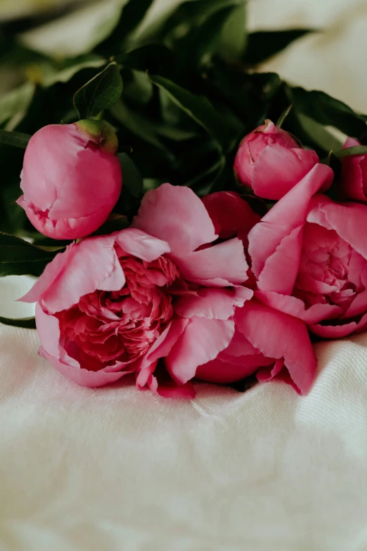 a bouquet of flowers with leaves sitting on top of a table