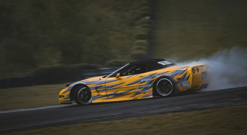 a close up of a sports car driving down a road