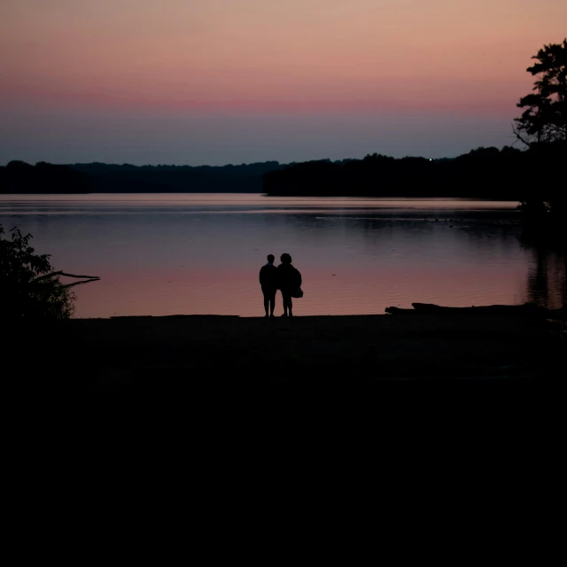 two people on a beach during sunset in the water