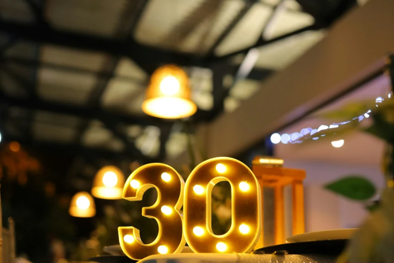 a lighted lit - up number that says 30 sits in front of the number 3