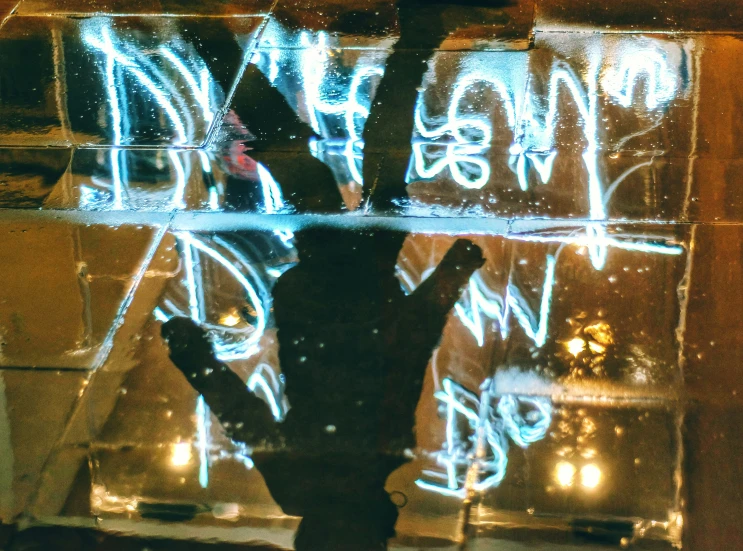 a person holding up a skateboard next to graffiti