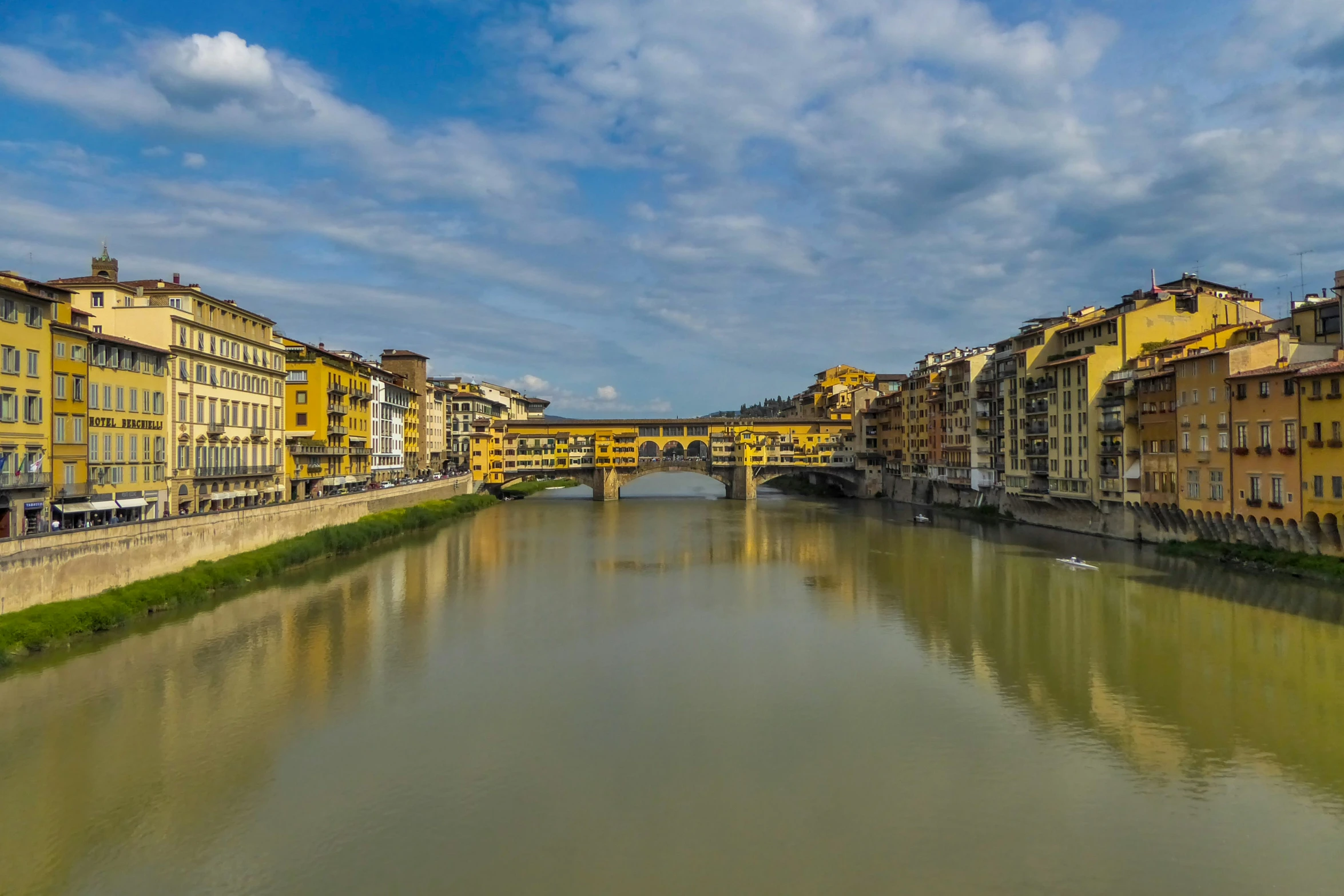 the river runs alongside the old city with many yellow buildings