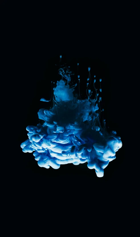 liquid is pouring into the water on a black background