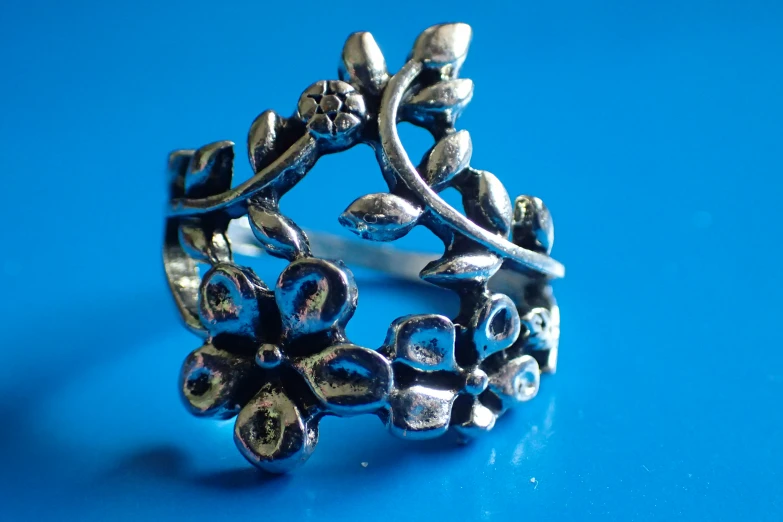 a ring with metal decorations sitting on a blue table