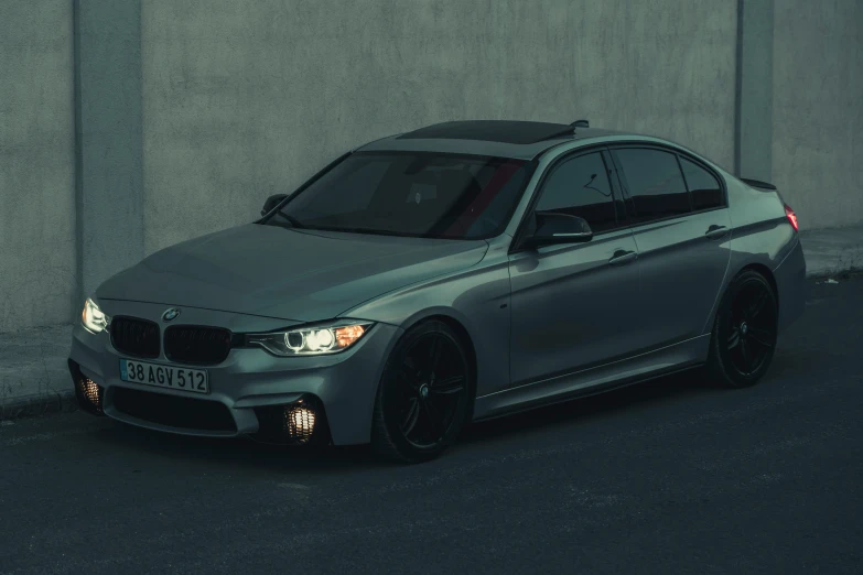 the front of a silver bmw is parked in front of a building