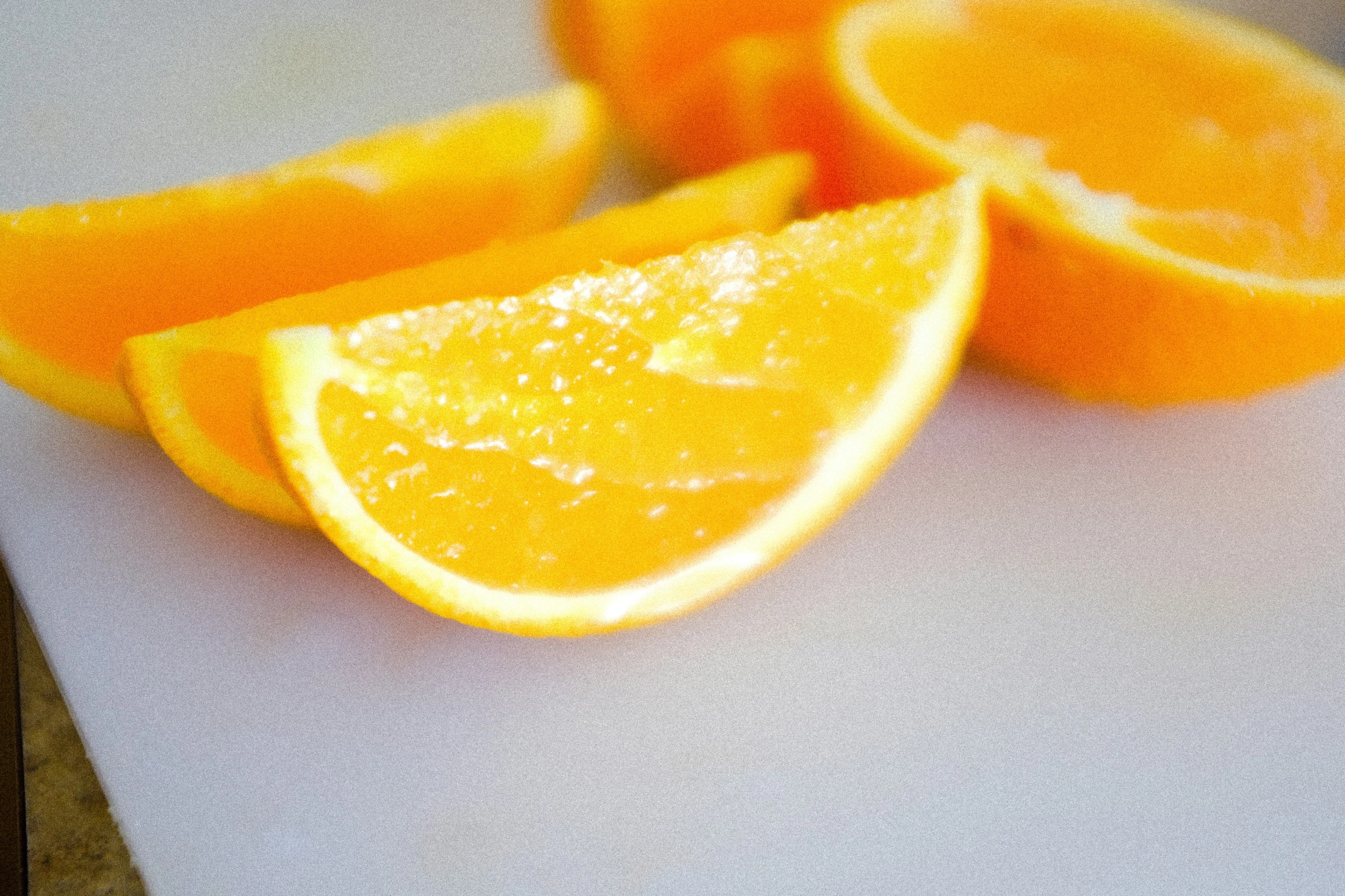 a cut orange is sitting on a  board