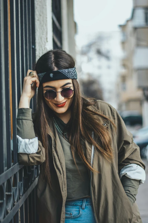 woman in sunglasses leaning on fence and smiling