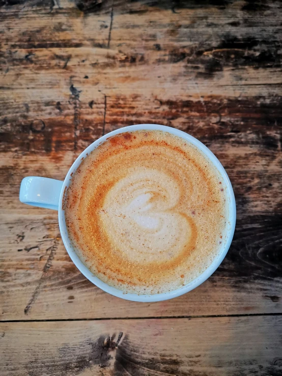 an overhead view of a cup of coffee with frothy saucer