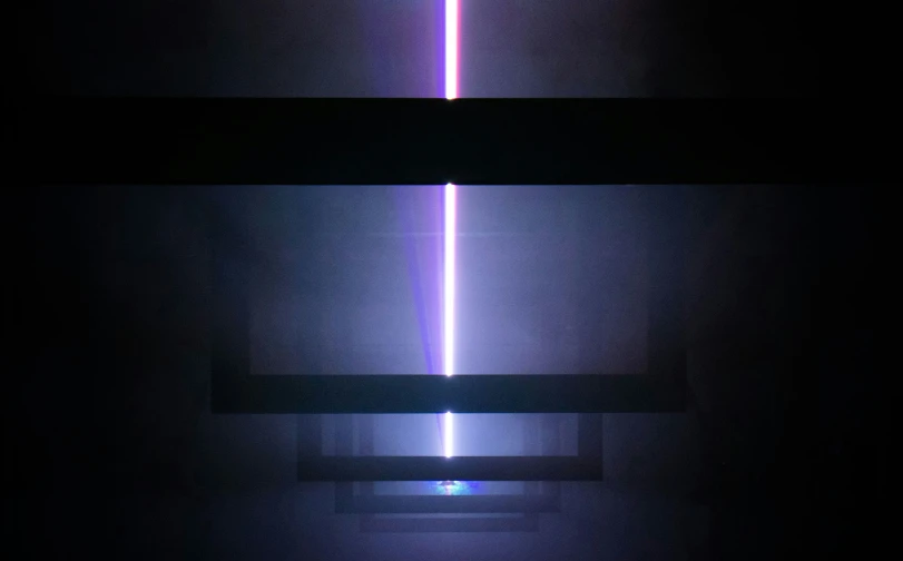 a light saber projected from a rectangular object in a dark room