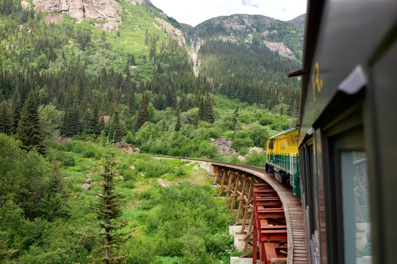 the train rides on tracks surrounded by mountains