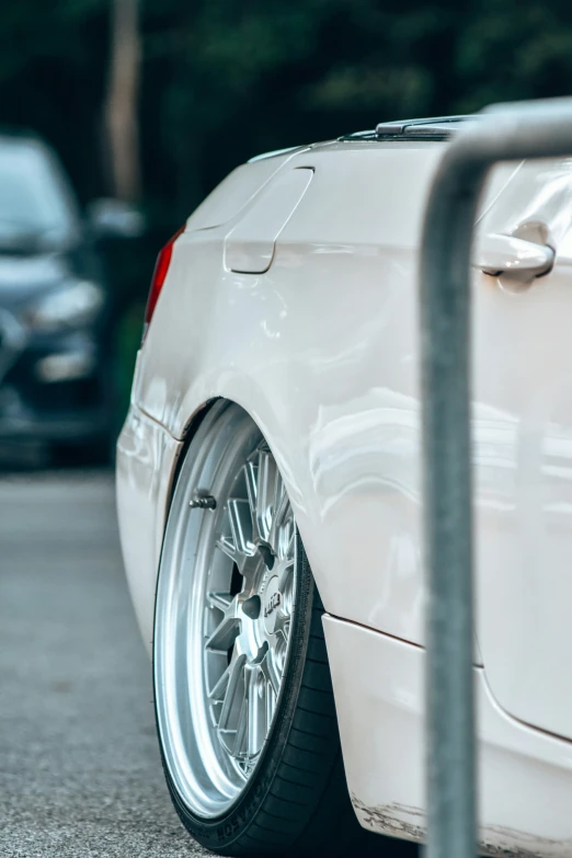 the wheels and rims on a white car are on the road