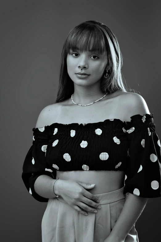 black and white po of a young woman in a polka dot blouse