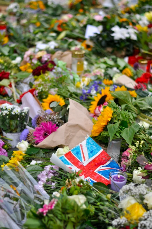 flowers and british flag laid out in the grass