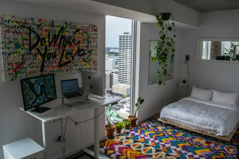 a room that has a bed, desk and a computer on it