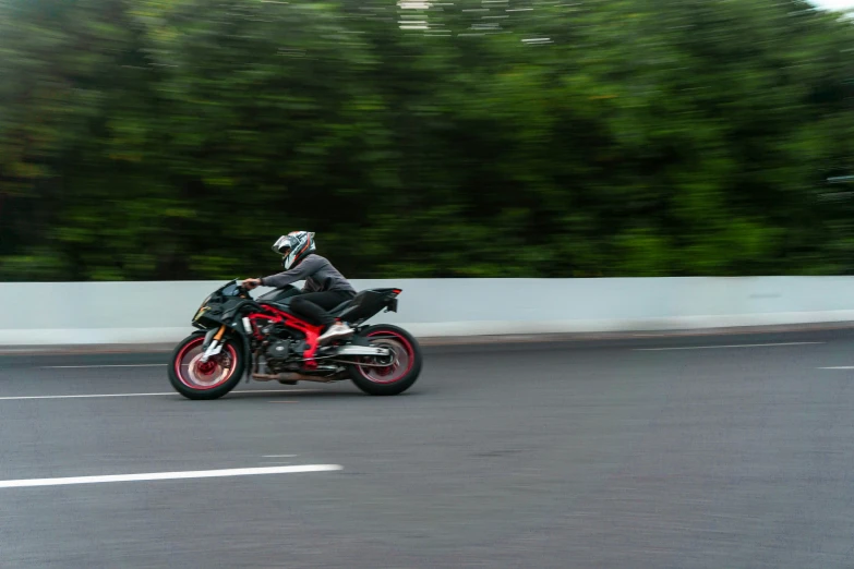 the biker is racing down the road on his motorcycle