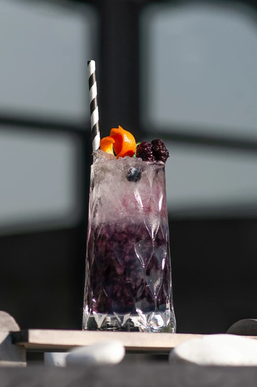 fruit salad sitting in a glass with a straw on the side