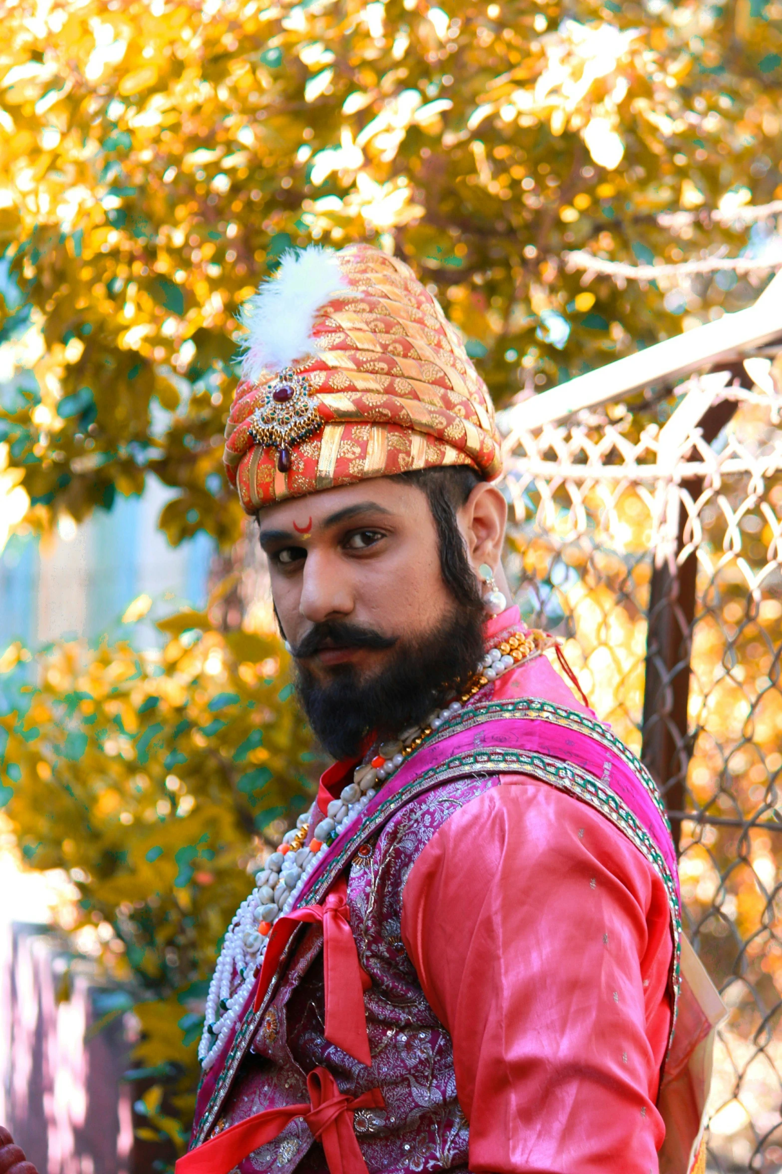 a man in indian garb outside with an umbrella