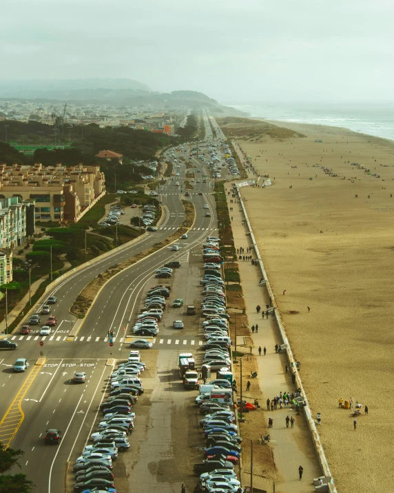 cars lined up along the beach near a large sandy area