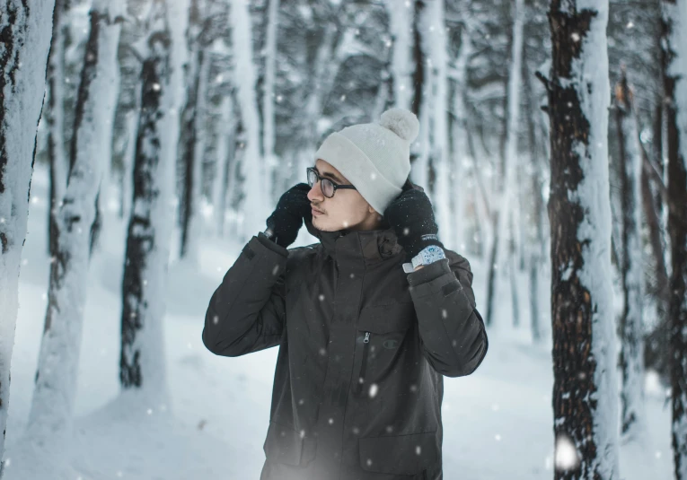 a woman standing in a forest with a hat on