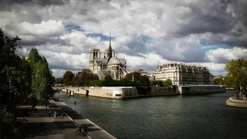 a po looking across a river with a cloudy sky above