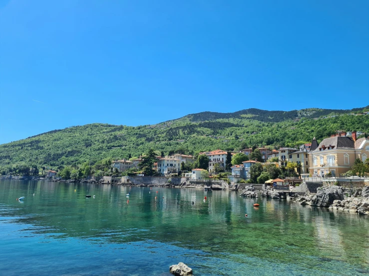 clear water on a mountain lake with houses on the shore