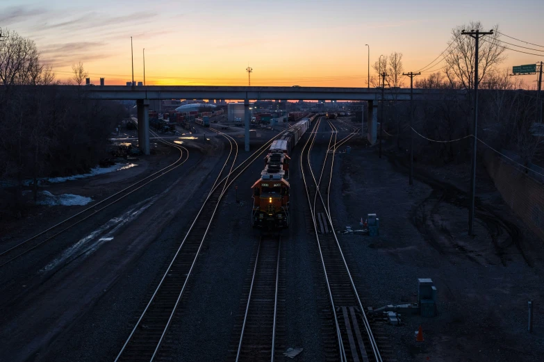 a train traveling on tracks into the sunset