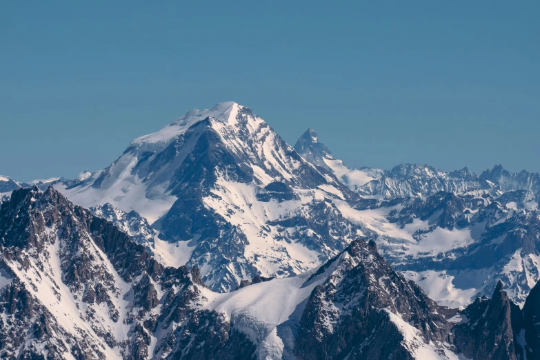 snow covered mountain tops with a bird flying in the sky