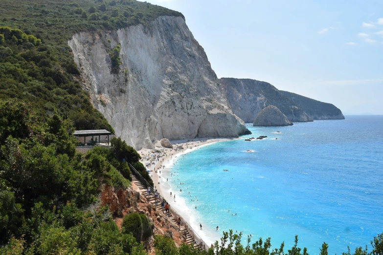 a very beautiful beach next to a huge hill