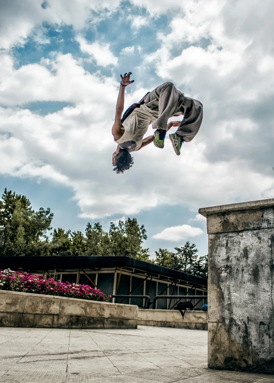 a skateboarder performing a trick on a cement ledge