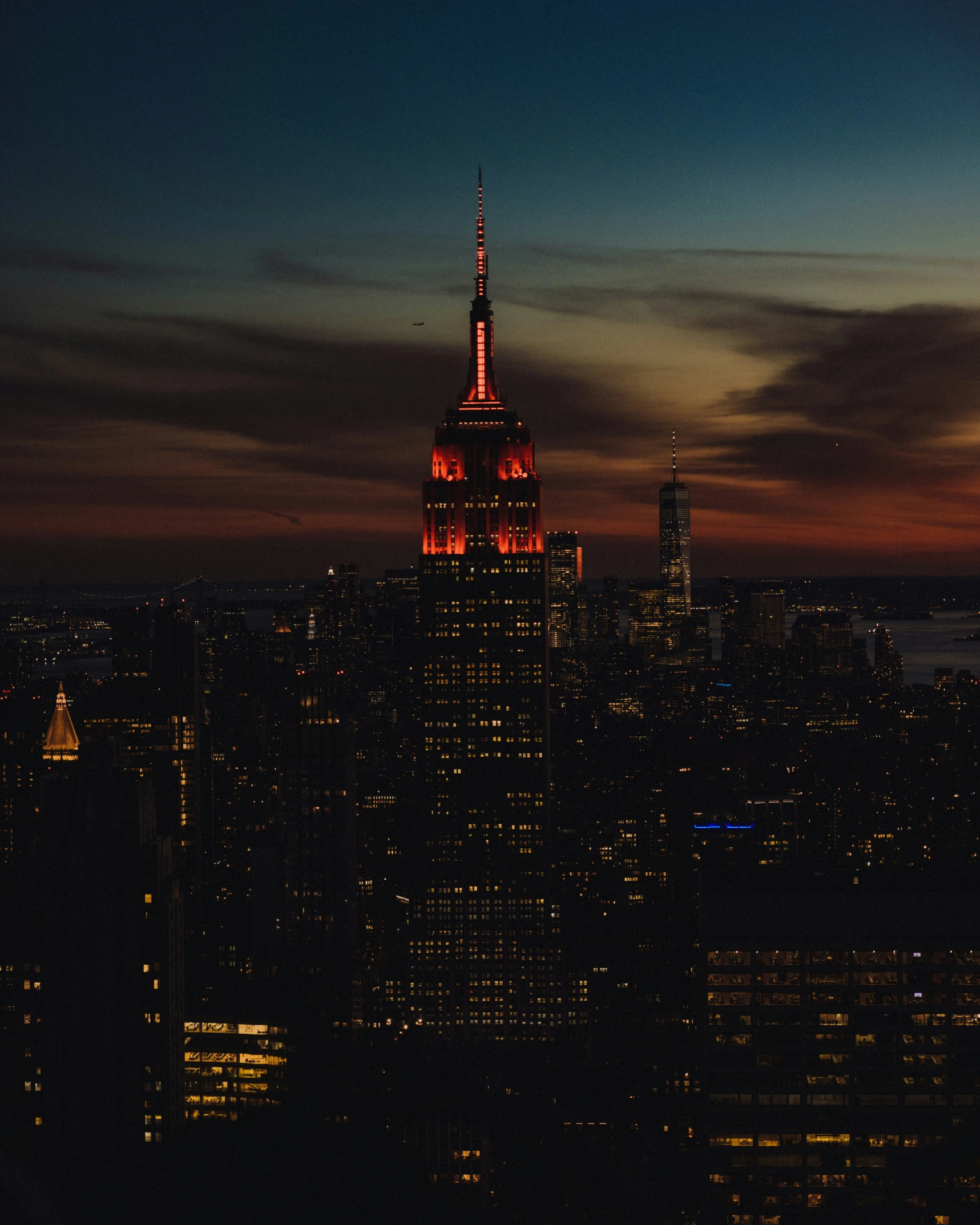 a very tall building with a neon orange light on top