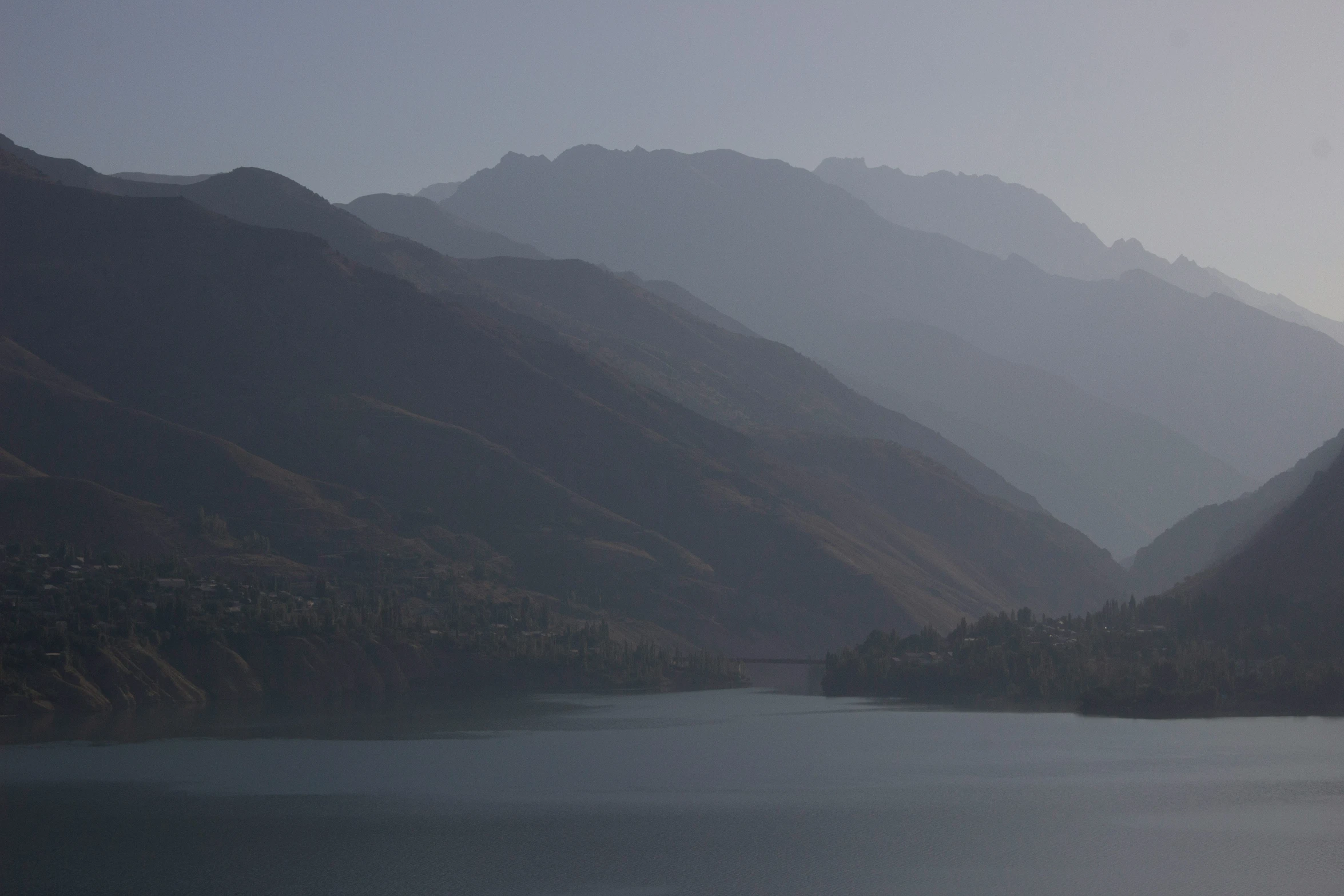 a group of mountains rise next to a large body of water