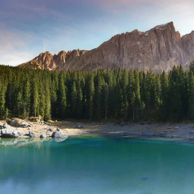 a bright blue pool in front of a mountain range