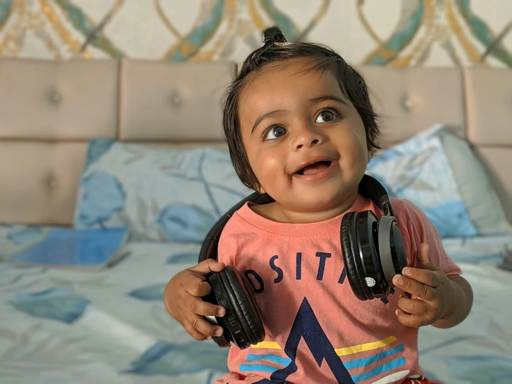 little girl holding headphones with her mouth and eyes open