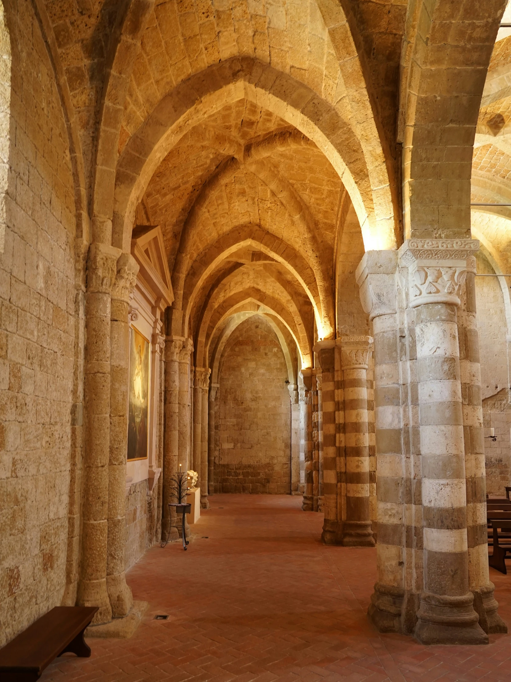 an empty hallway between two buildings that are made out of stone