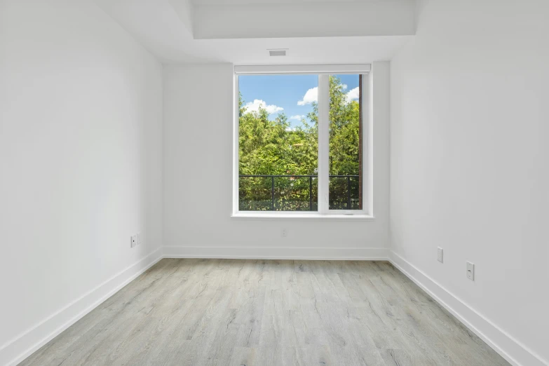 empty room with white walls and a view out the window