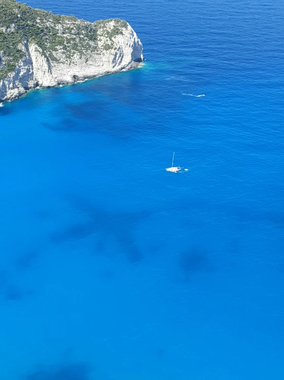 there is a boat in the water with the cliffs in the background