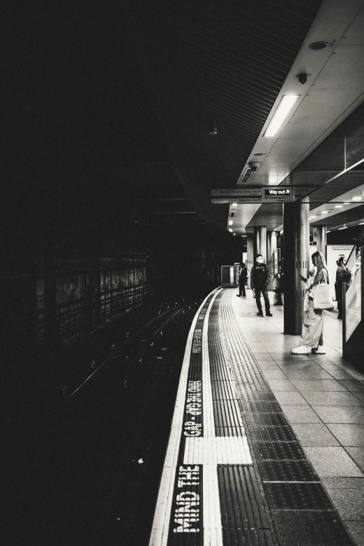 an empty subway station has people standing and standing around