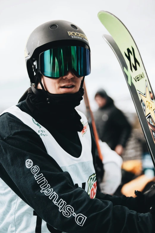 a man is holding a snowboard wearing a helmet