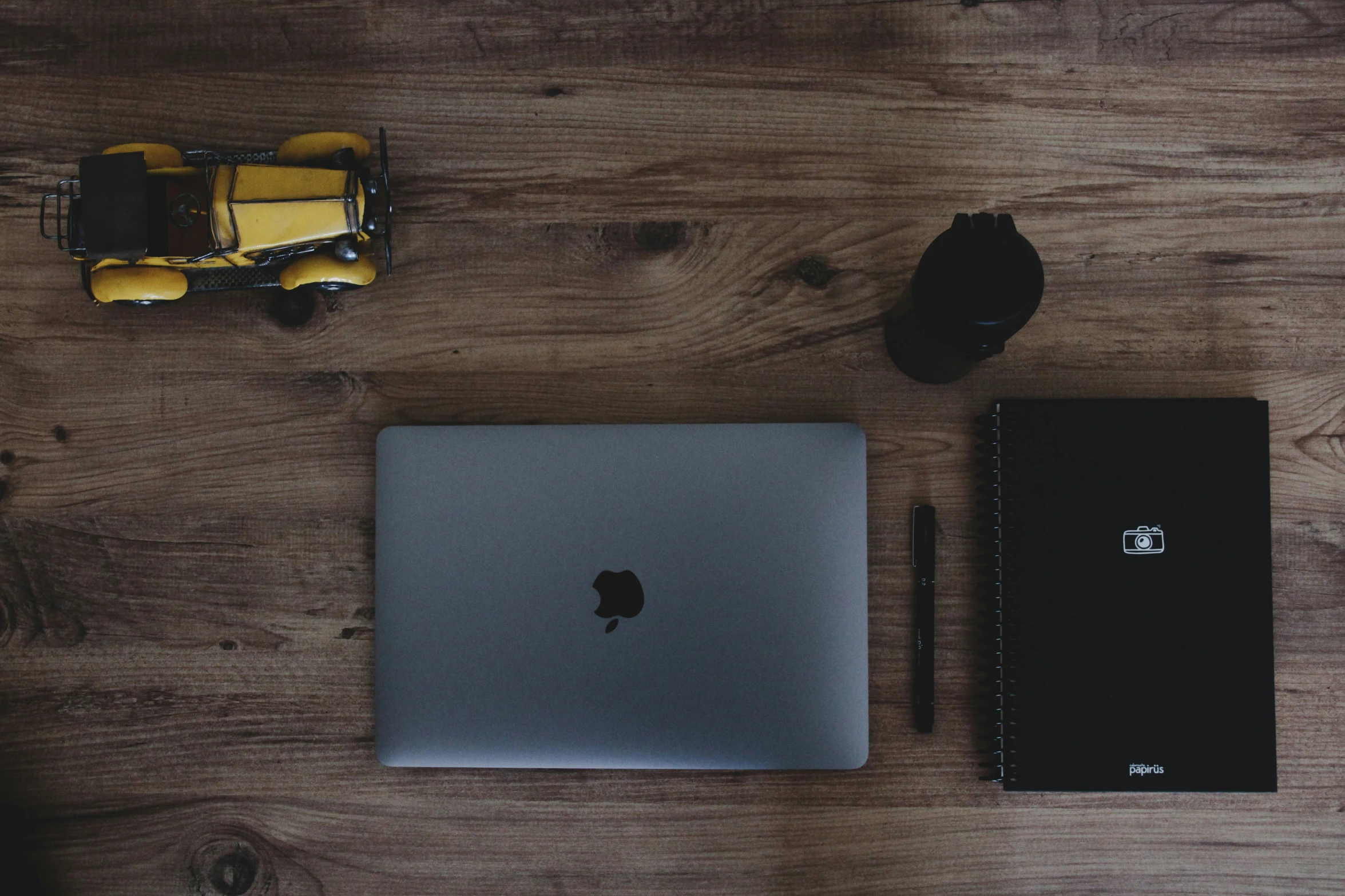 an apple laptop sitting on top of a wooden desk