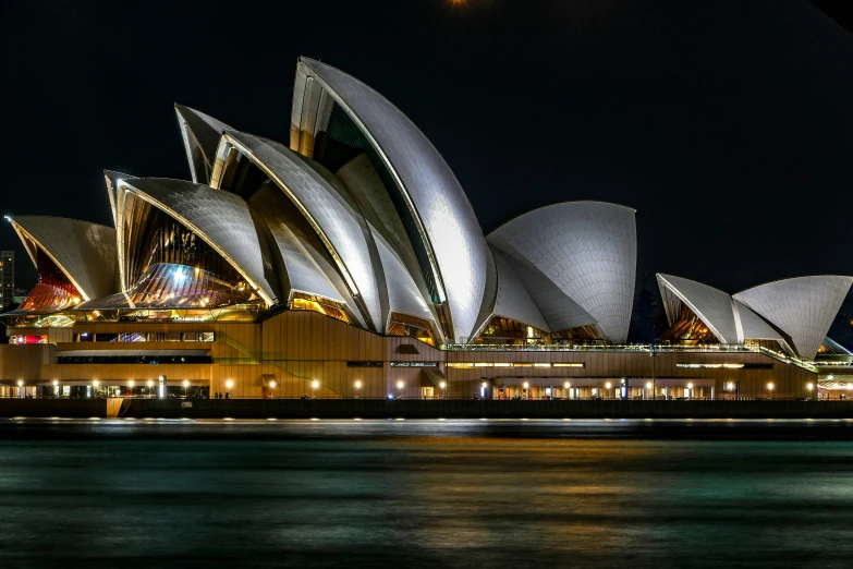 a building lit up next to a body of water