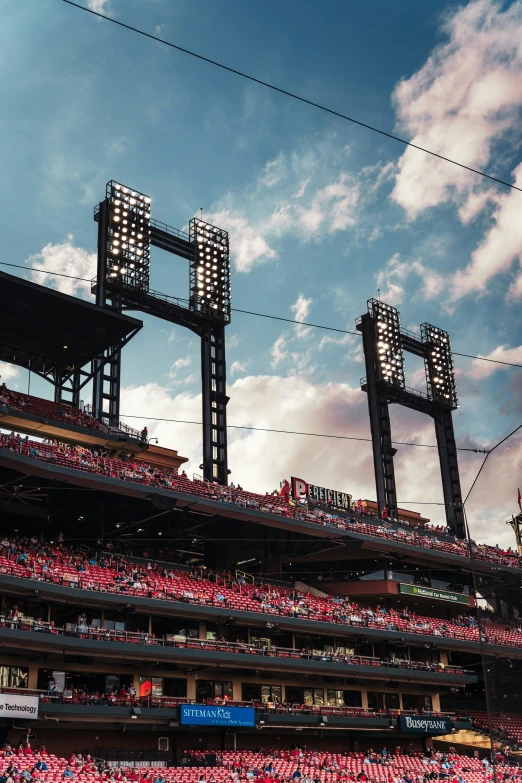 a baseball stadium with large scoreboards and a sky background