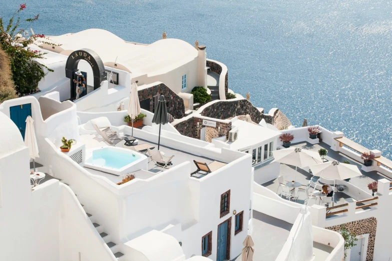 a roof top view of a white house with water