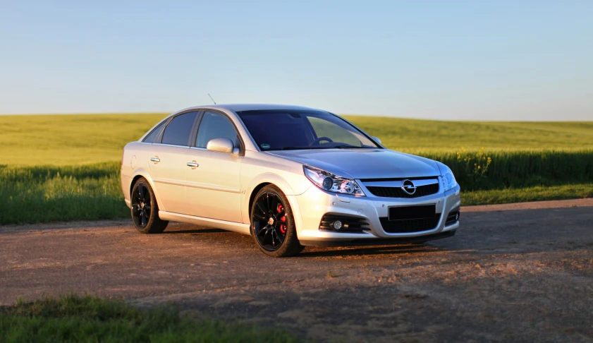 a white car is parked on a rural road